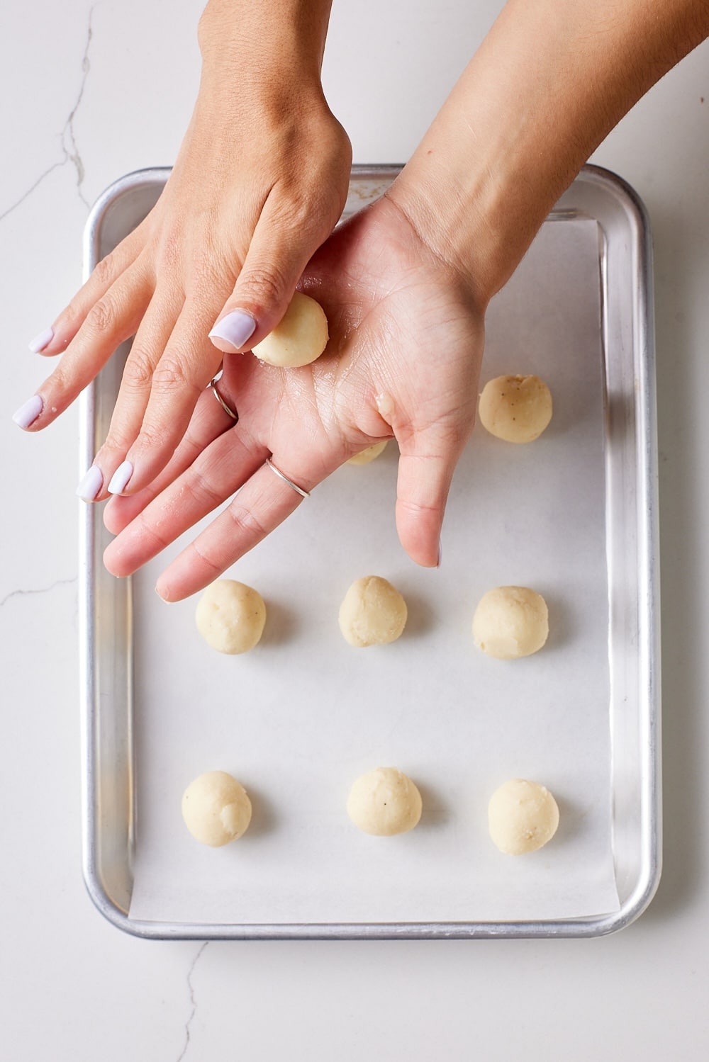 Eggnog Truffles5 Scoop and roll eggnog truffles into balls then place on the parchment-lined tray.
