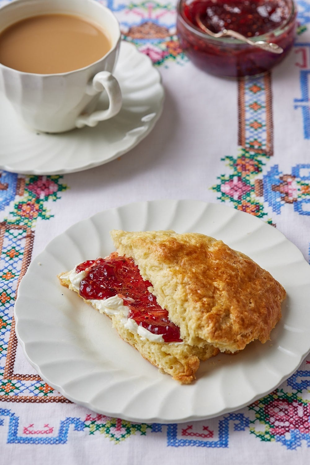 Irish Soda Bread Scones9 One wedge of soda bread scone served with butter and jam. Tea is on the side .