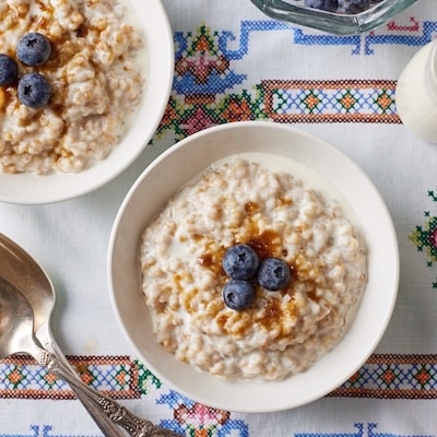 Top-down view of Irish Oats served in two bowls with brown sugar and blueberries.