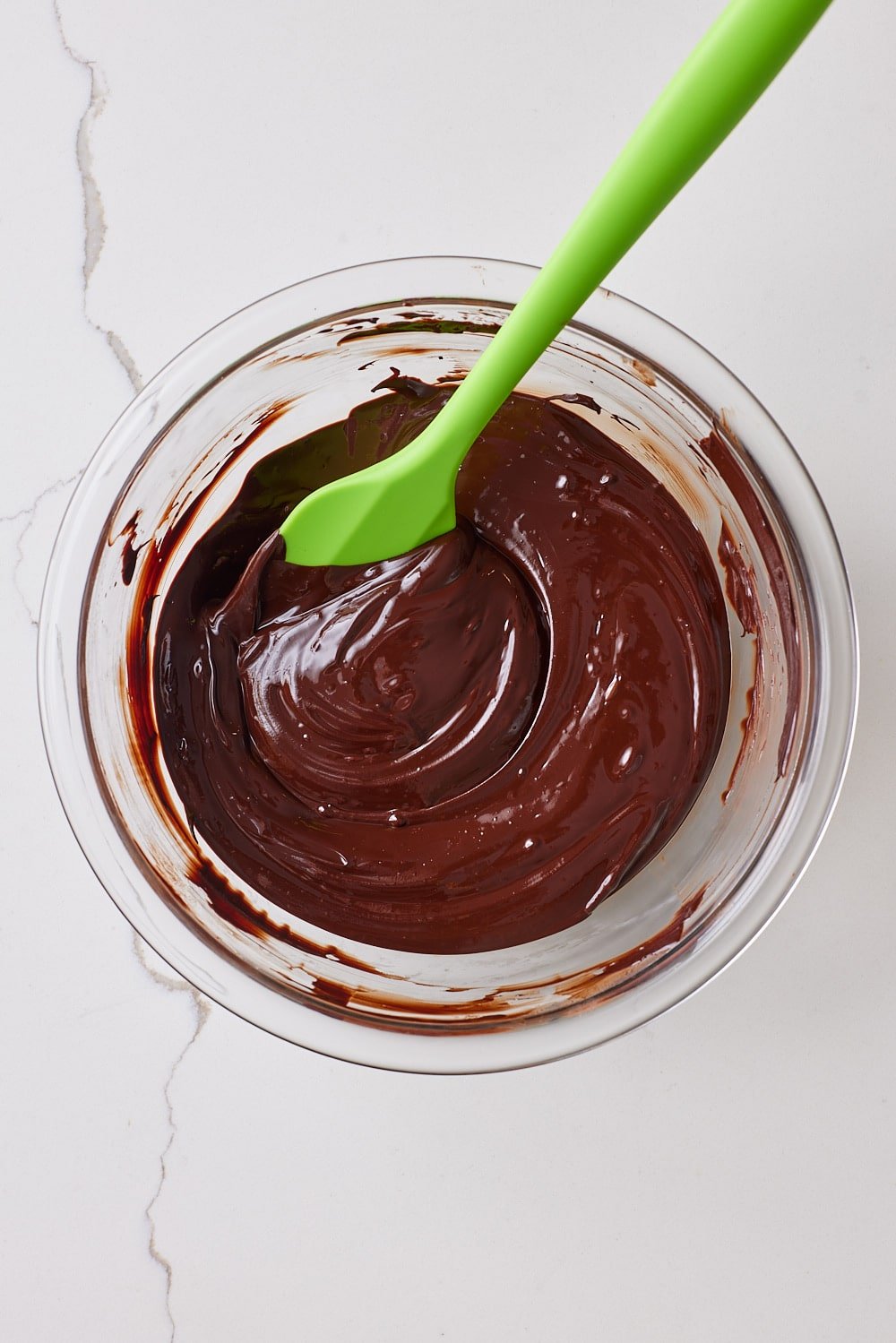 Sourdough Brownies2 Melted chocolate and butter with cocoa powder in a glass bowl with a spatula.