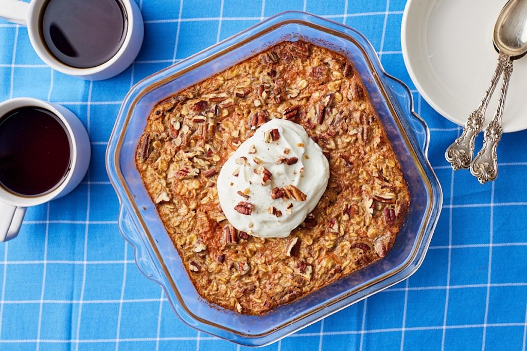 Top-down view of Carrot Cake Baked Oatmeal in a glass dish served with yogurt and pecans.