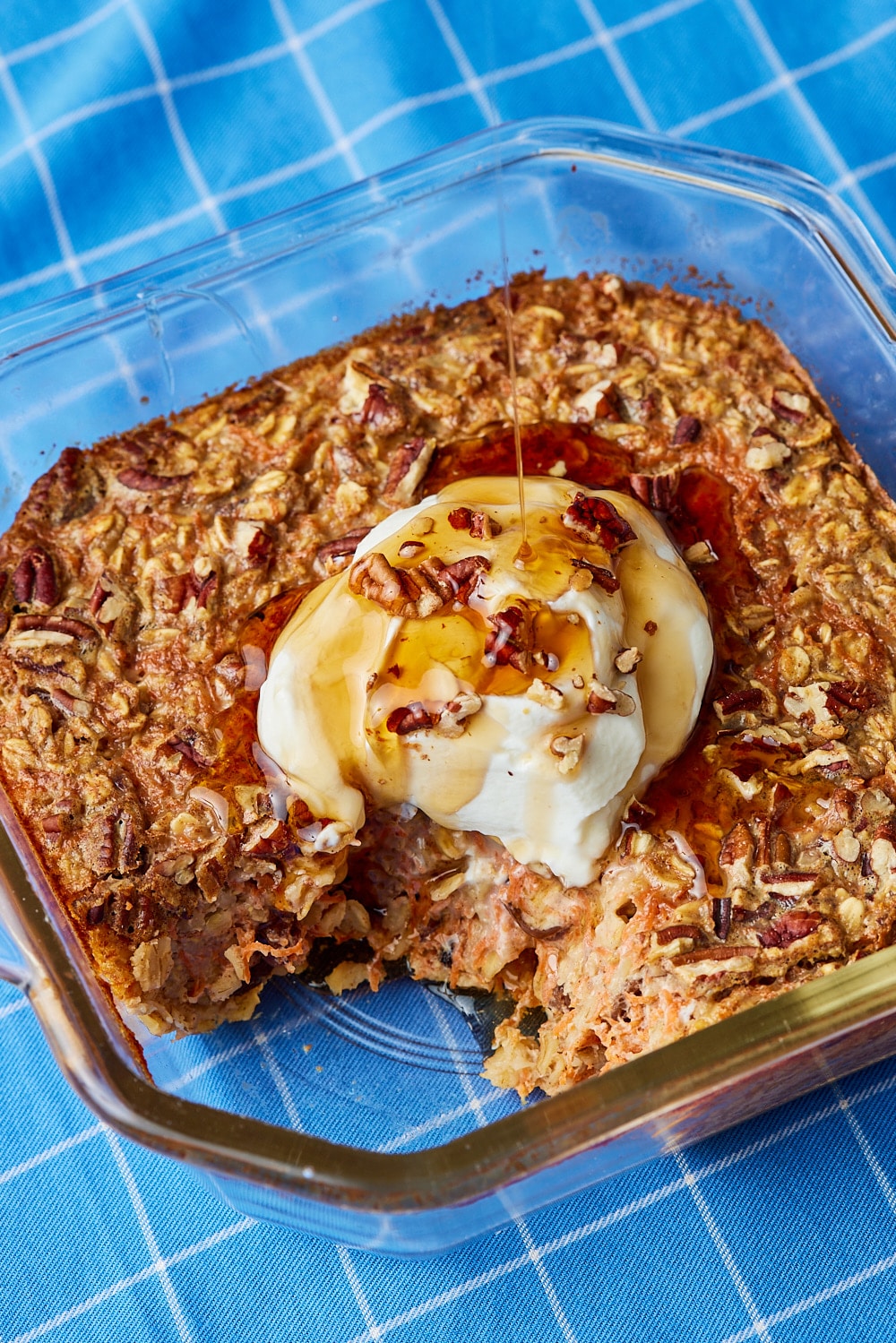 Carrot Cake Baked Oats8 Carrot Cake Baked Oatmeal served with yogurt, pecans, and maple syrup. One corner has been scooped out.