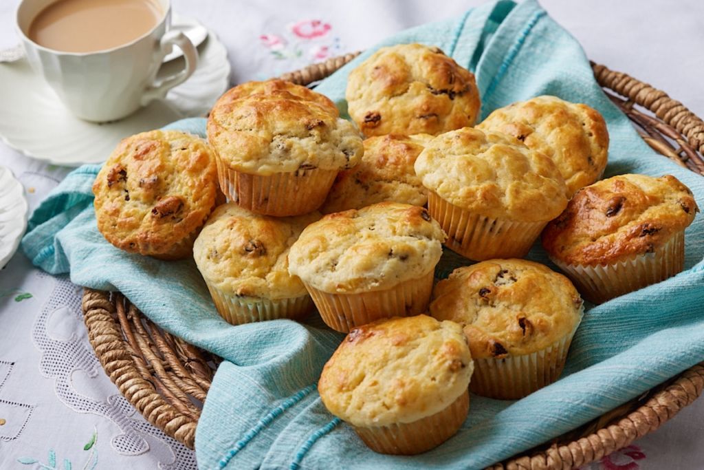 A basket of golden fish Soda Bread Muffins served with tea on the side.