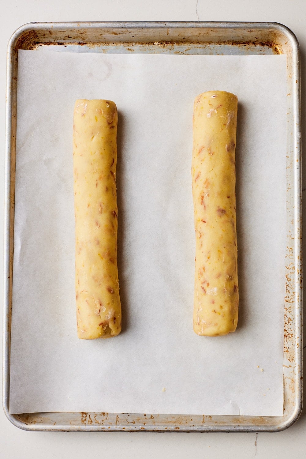 Make biscotti logs: Roll each portion into a 12-inch (30 cm) log and place on the prepared baking sheet, spaced well apart. 