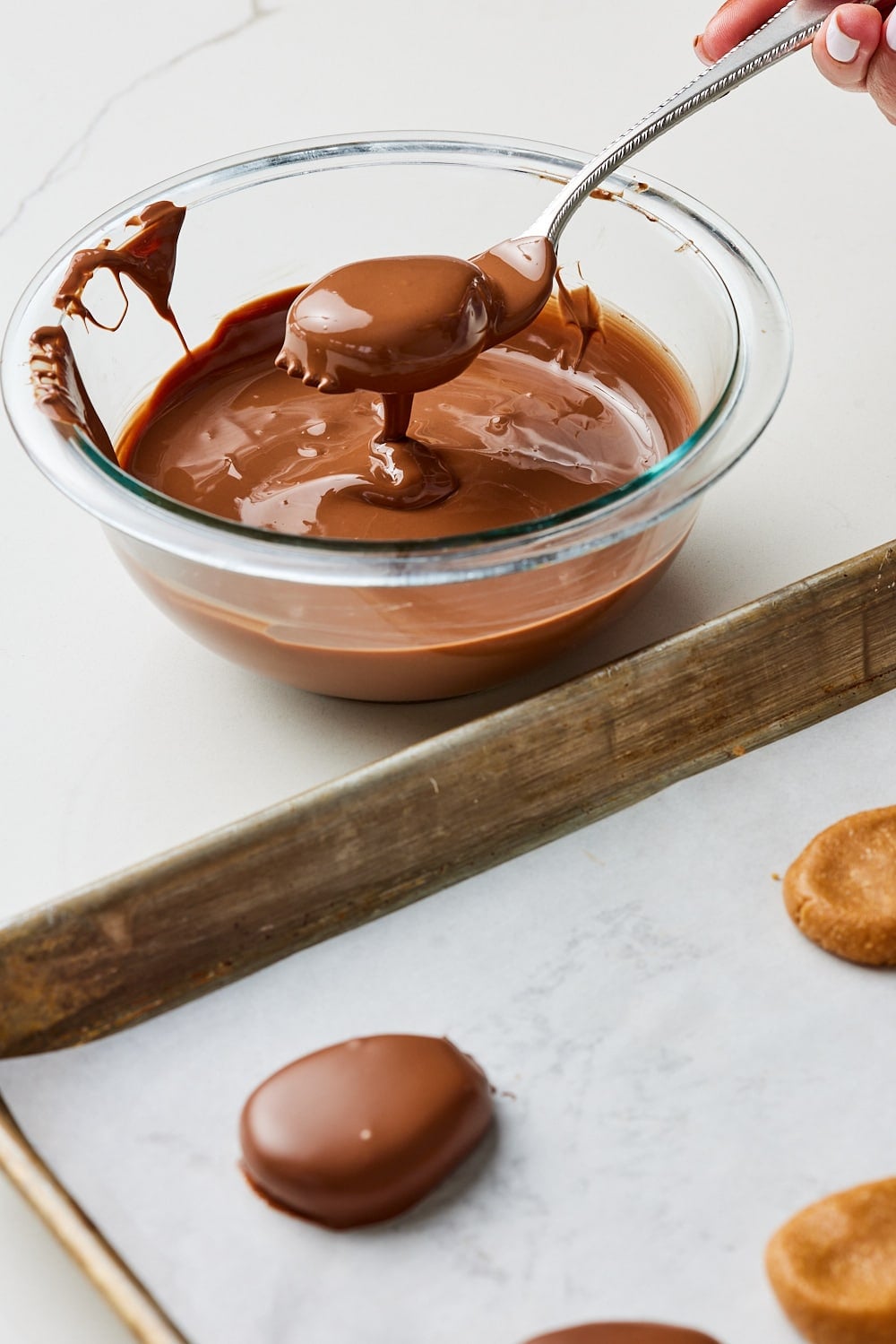 Peanut butter eggs7 Place on tray: Tap the fork gently on the edge of the bowl to remove excess chocolate, then place the coated egg on your other prepared tray.
