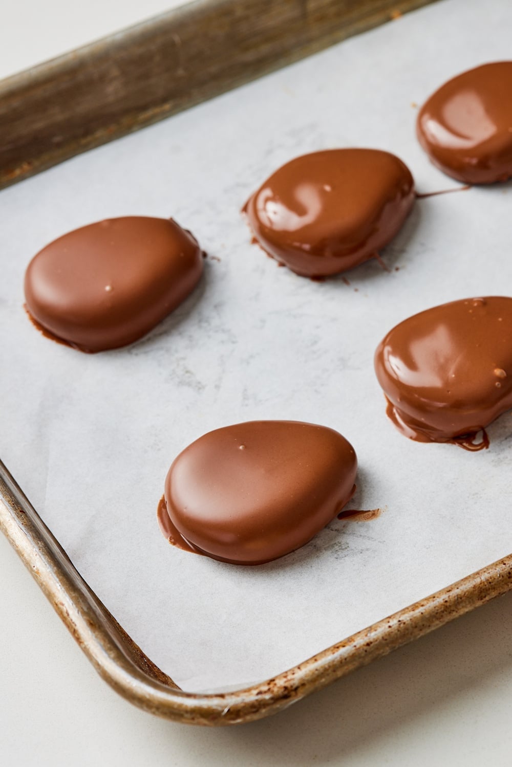 Peanut butter eggs8 Peanut butter eggs coated with chocolate on a baking tray.