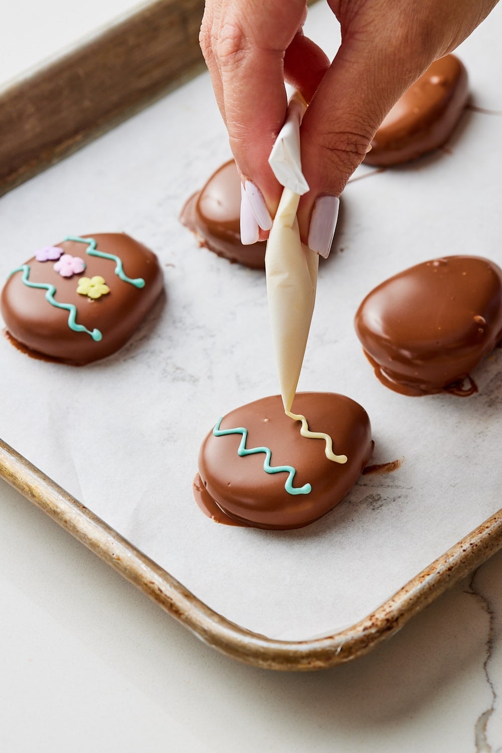 Peanut butter eggs9 Decorate peanut butter eggs with candy melts in a pipping bag.