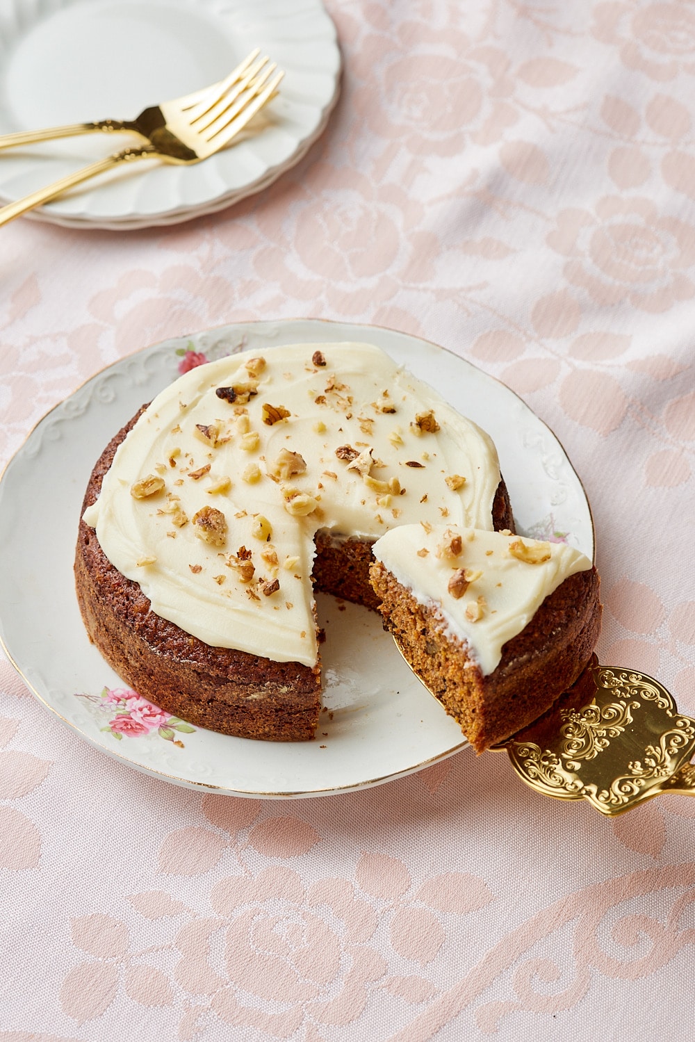 Small Carrot Cake Recipe9 A slice of small carrot cake is being cut and lifted away from the whole cake.