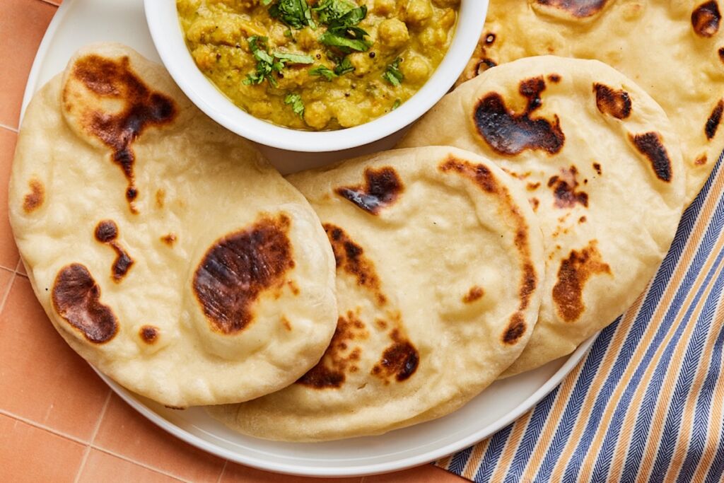 Top-down view of sourdough naan with a bowl of chickpea dip.