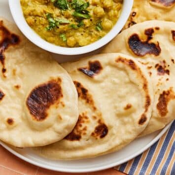Top-down view of sourdough naan with a bowl of chickpea dip.