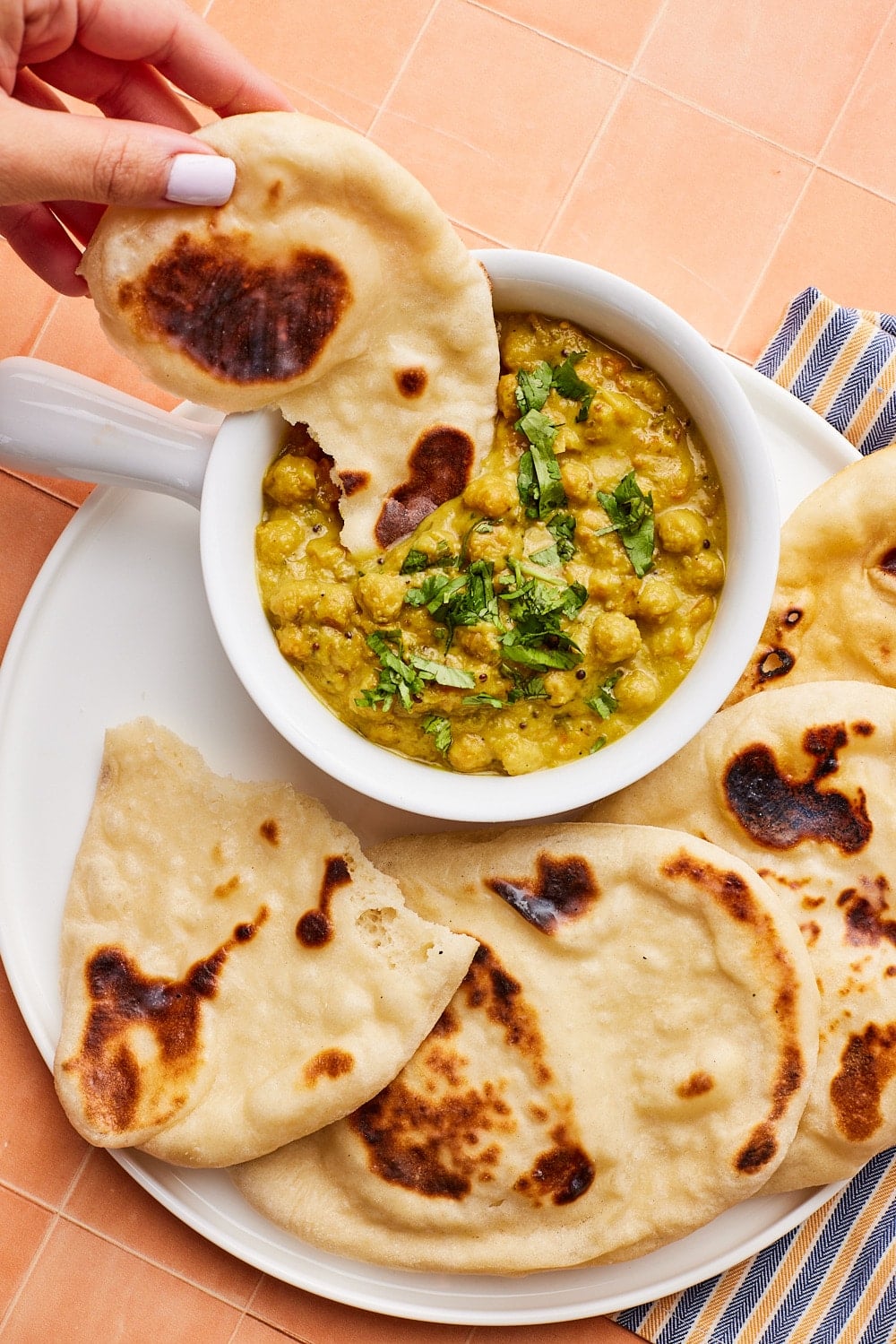 Sourdough dipping into a bowl of chickpea dip. 