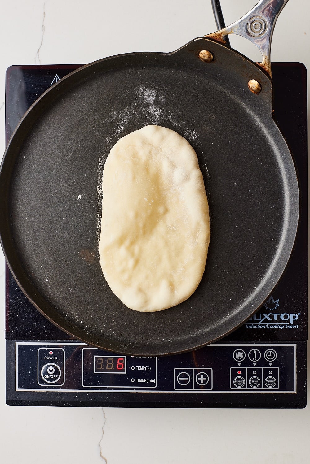 Cook one naan at a time for about 2 minutes on the first side, until bubbles form.