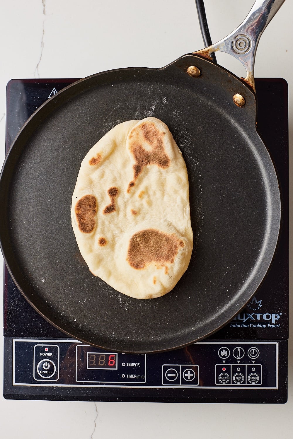 Flip naan: Flip and cook for about 2 minutes on the second side, until charred and puffed.
