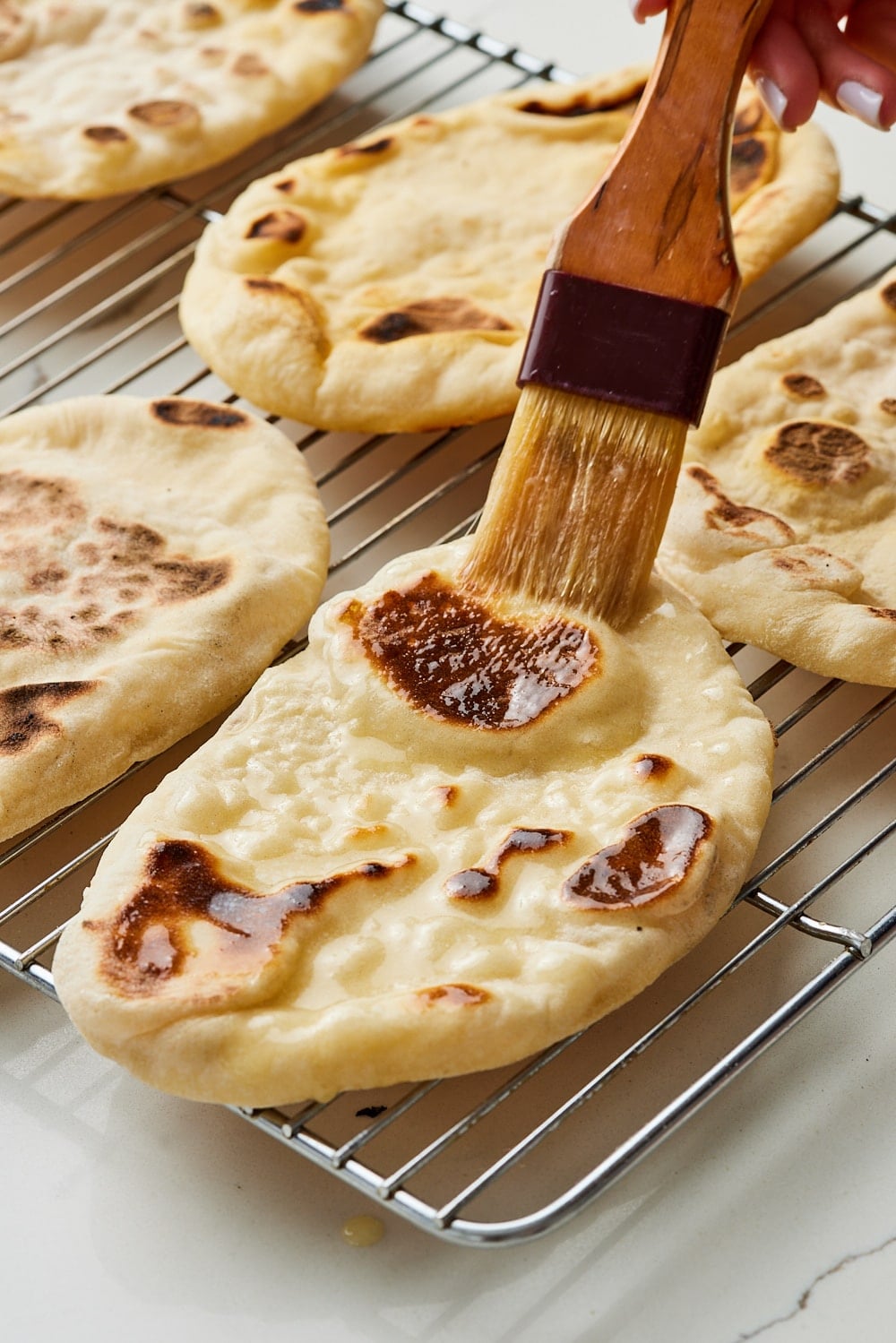 Brush ghee or butter onto cooked sourdough naan. 