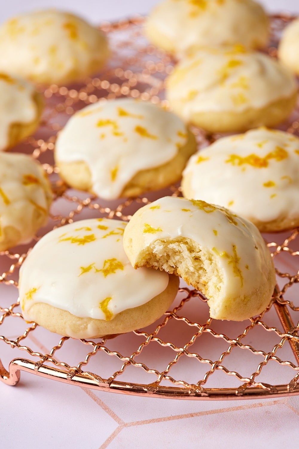 Lemon ricotta cookies9 A close-up shot at lemon ricotta cookies on the cooling rack , with one cookie having a bite taken.