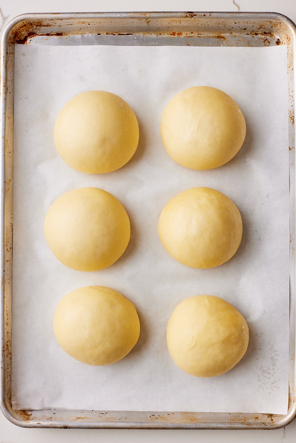 Brioche Burger Buns6 Proof brioche dough balls on the baking tray.