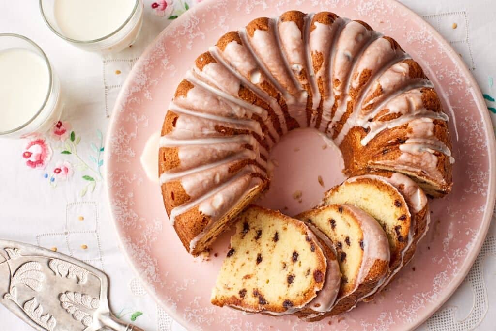 Top-down view of the chocolate chip pound cake with part of it sliced. Served with milk on the side.