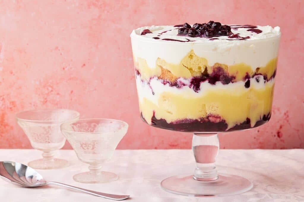 Lemon Blueberry Triffle in a big glass bowl with layers of cakes, filling, lemon curd, and whipped cream.