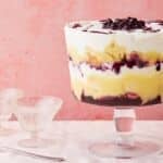Lemon Blueberry Triffle in a big glass bowl with layers of cakes, filling, lemon curd, and whipped cream.