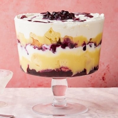 Lemon Blueberry Triffle in a big glass bowl with layers of cakes, filling, lemon curd, and whipped cream.