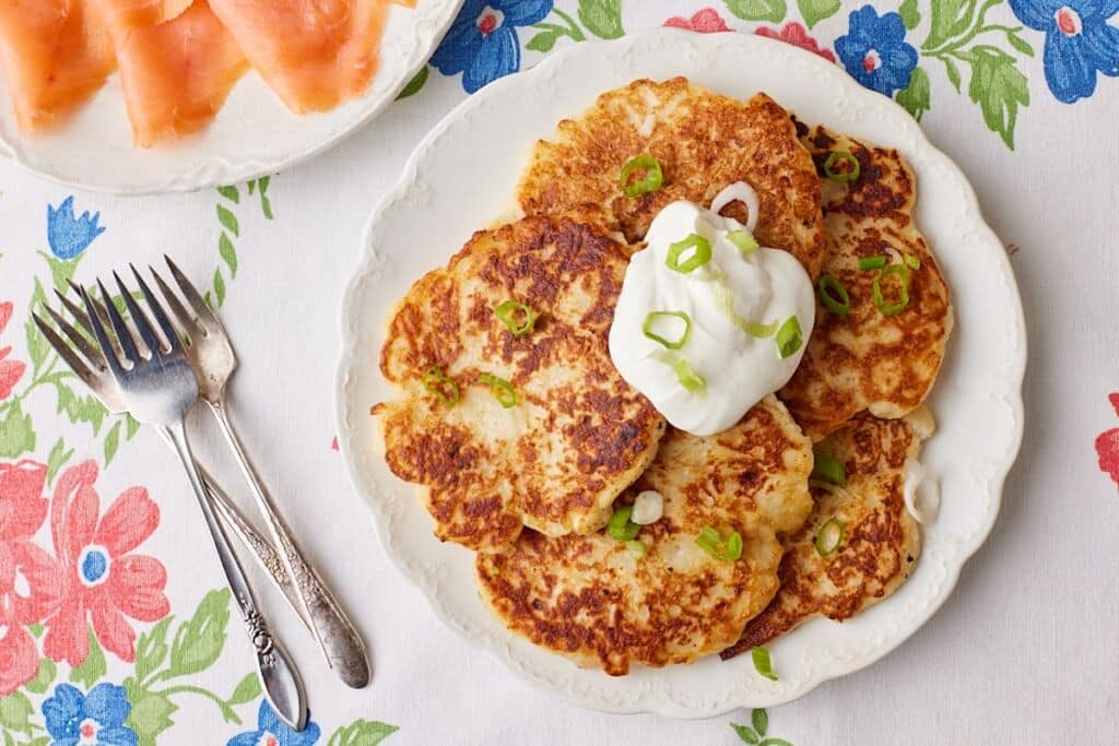 Top-down view of Boxty- Irish Potato Pancakes topped with sour cream and green onions.