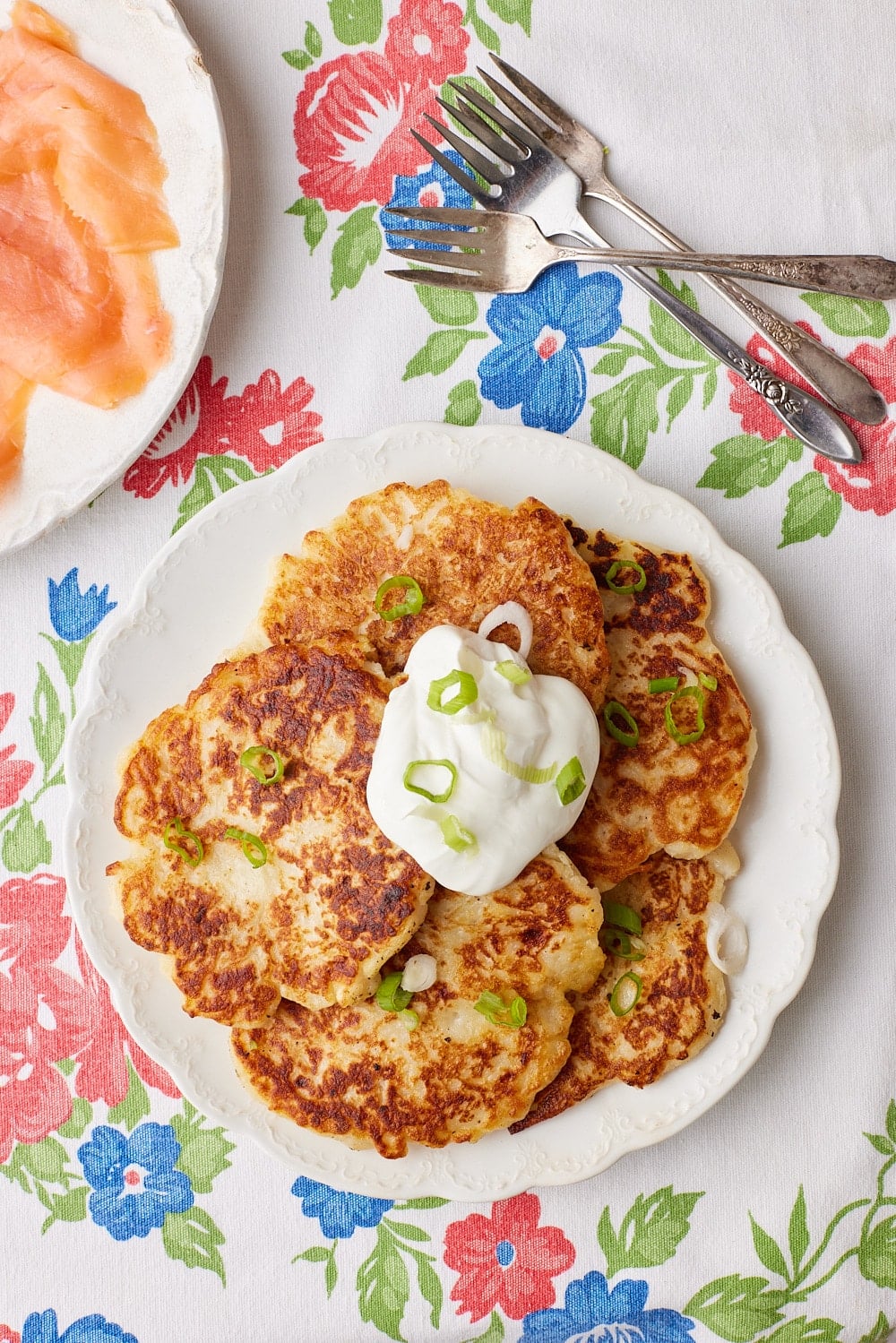 Boxty13 Top-down view of a plate of Irish Potato Pancakes served with sour cream on top and smoked salmon on the side.