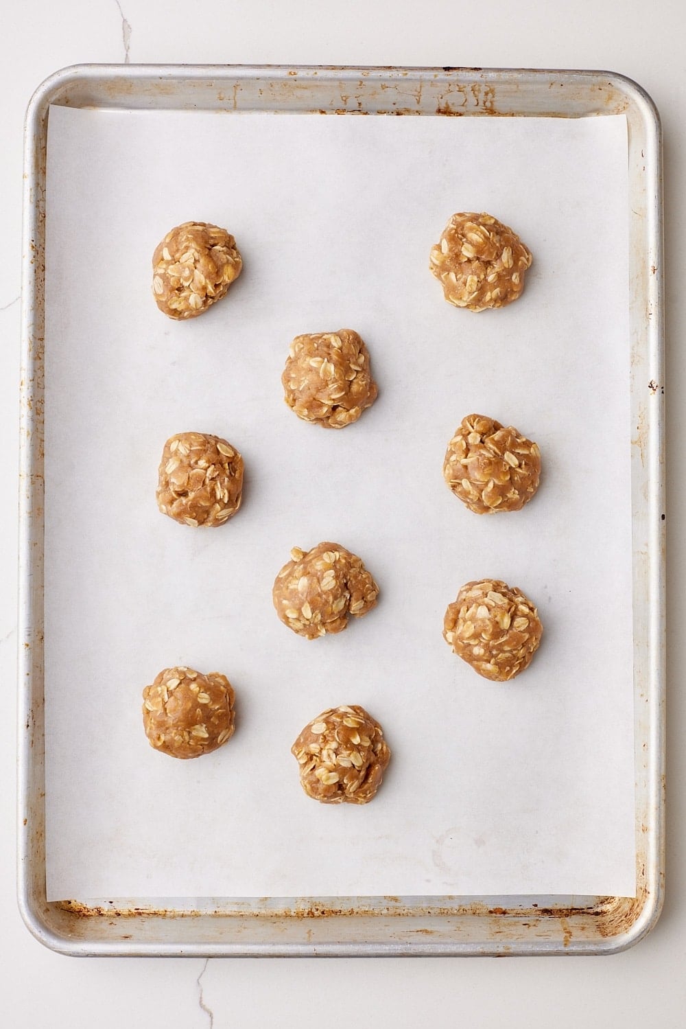 Brown Butter Oatmeal Cookies7 Scooped browned butter cookie dough balls on a baking tray.