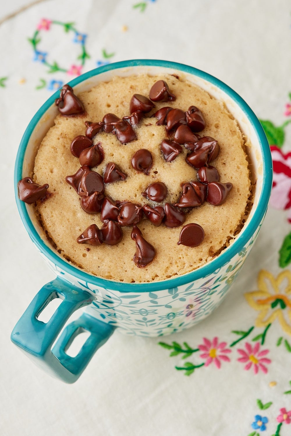 Top-down view of a chocolate chip mug cake with chocolate chips on top. 