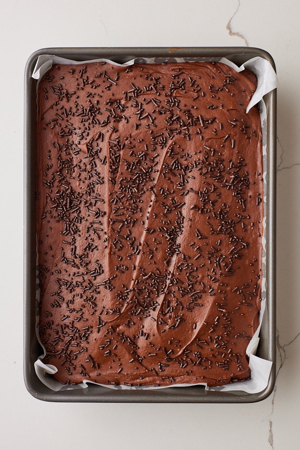 Coca Cola Cake15.1 Top down view of Coca Cola Cake with frosting and chocolate sprinkles.
