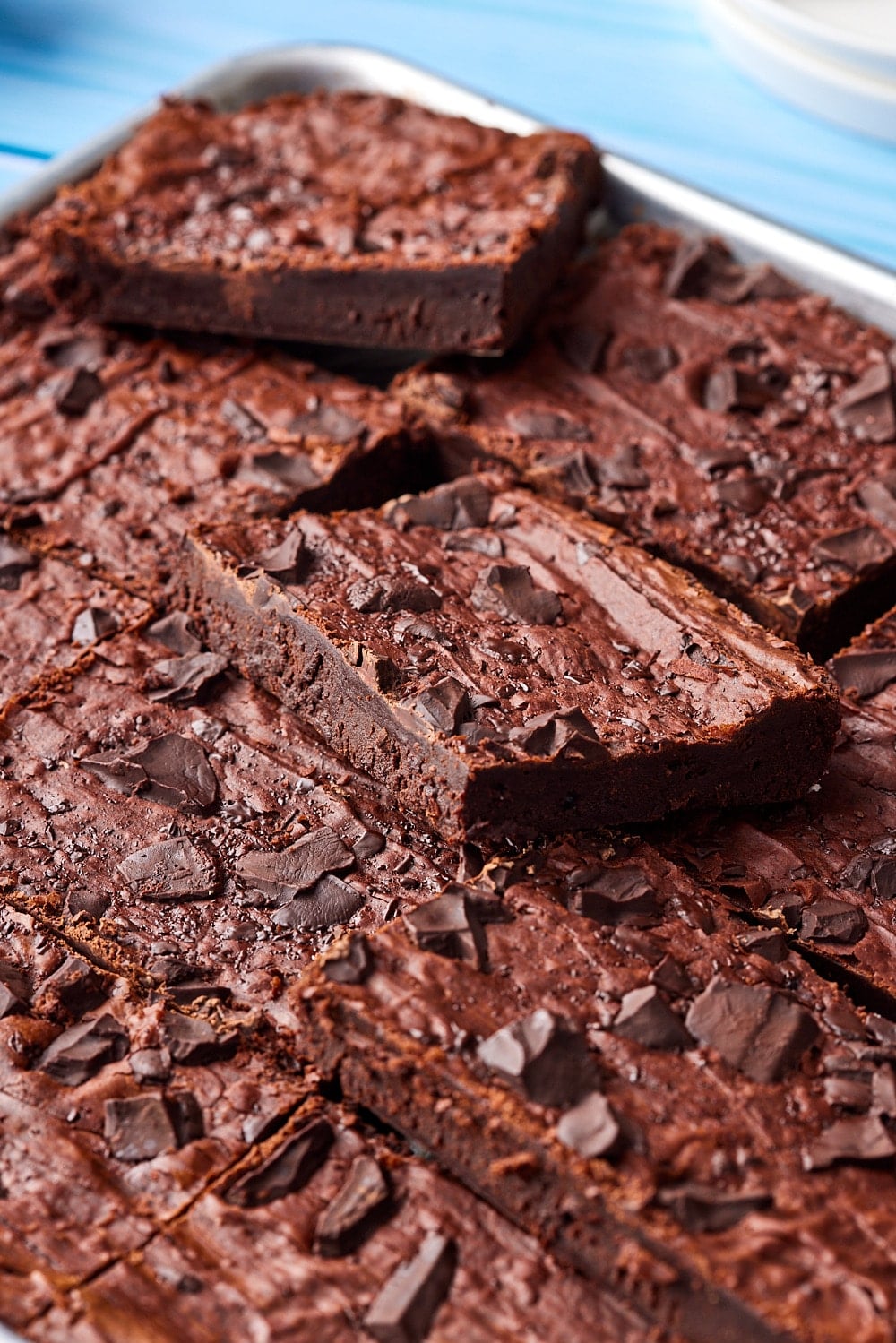 Sheet pan brownies with crackly top chewy edges and fudge center.