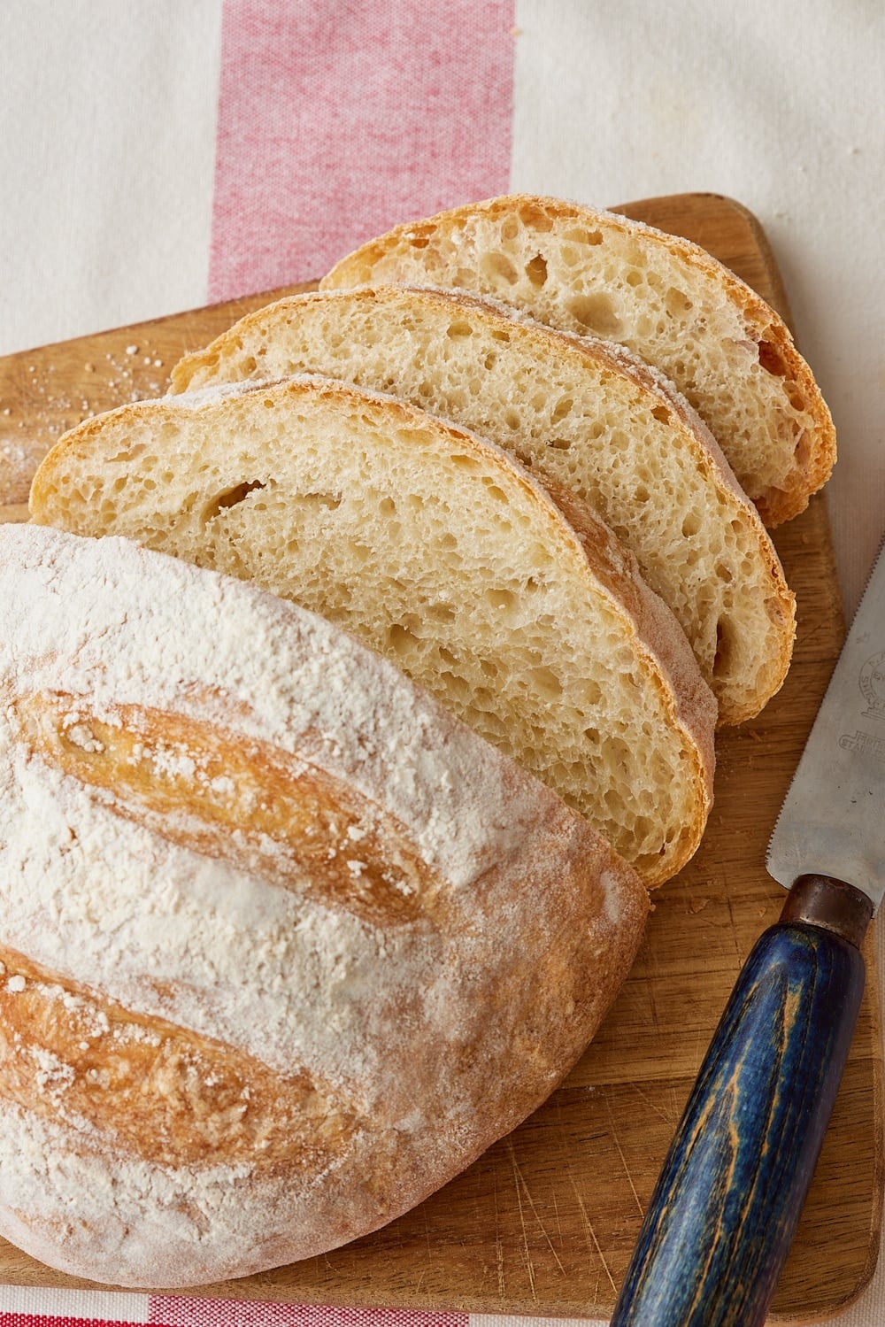 A loaf of small bread with crusty bread on the wooden board. 