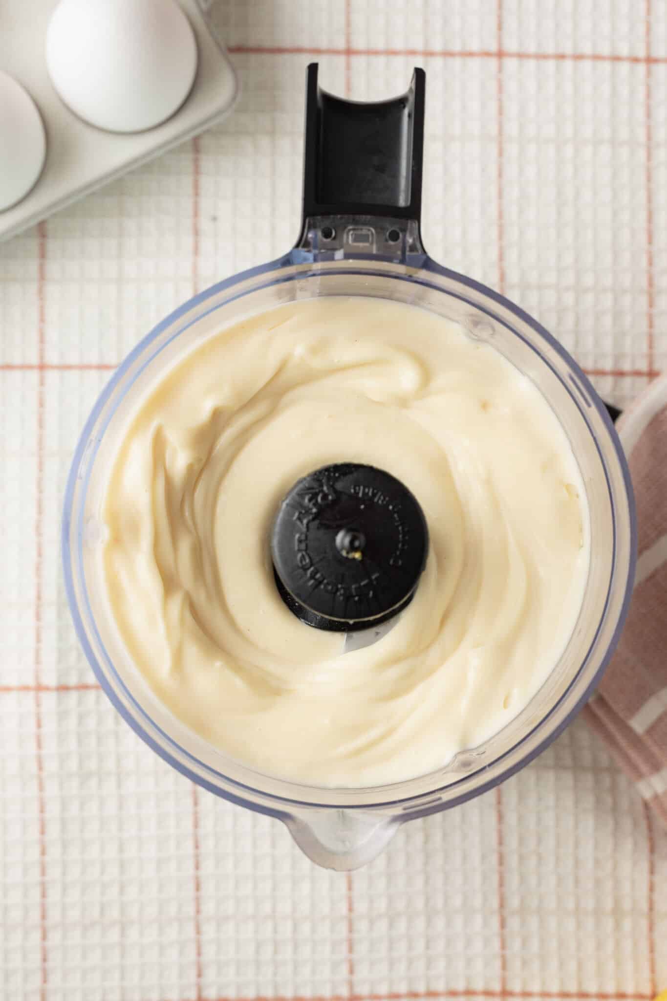 Top-down view of homemade mayonnaise in food processor. 