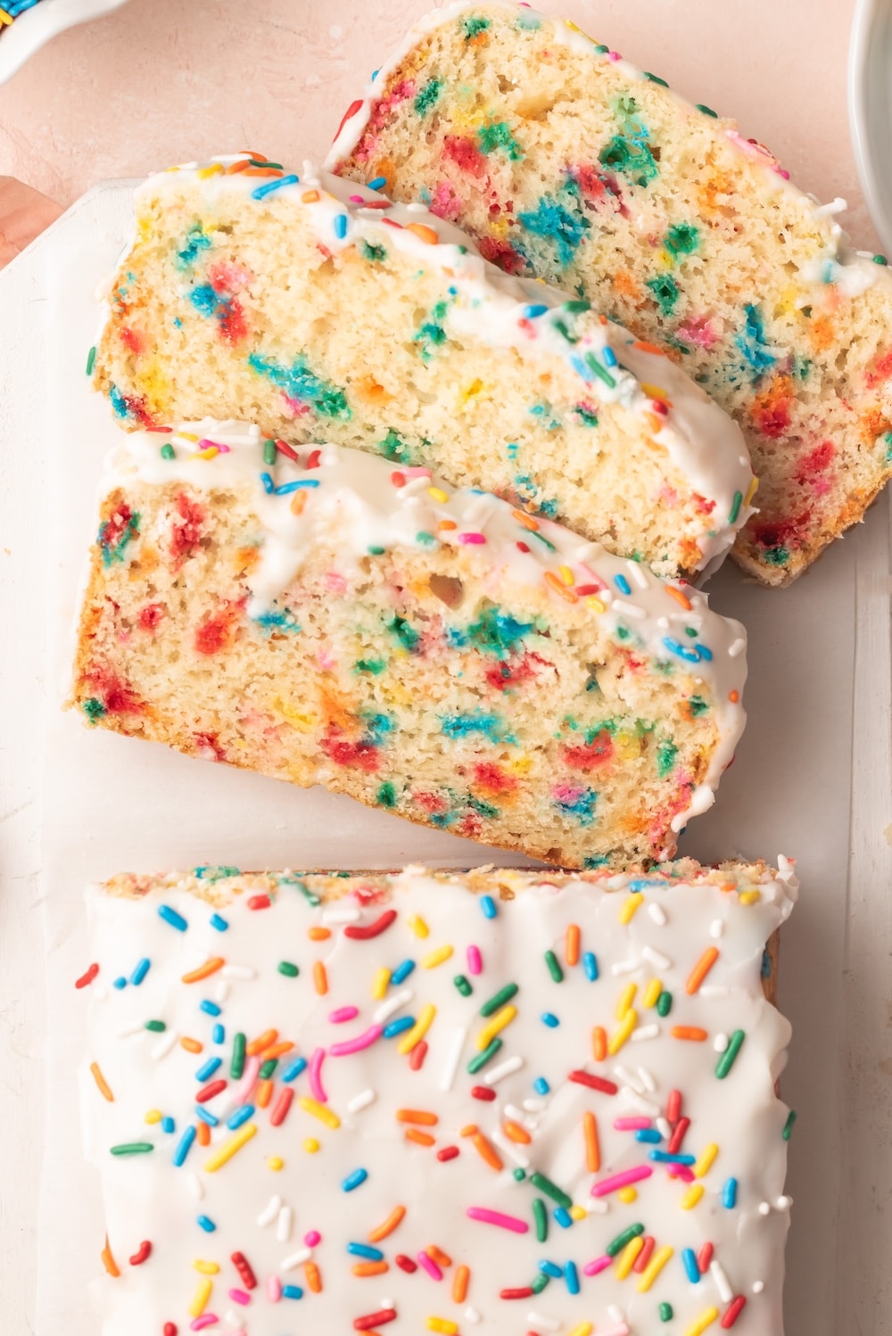Ice Cream Bread 2 Ice Cream Bread with half loaf sliced into three slices. It's covered with icing and has sprinkle in the crumb and in icing.