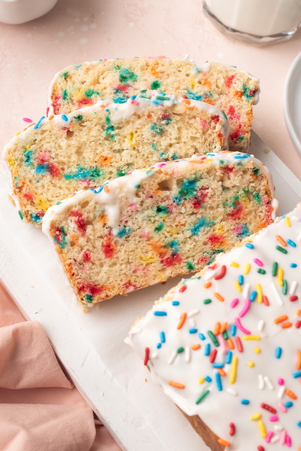 Ice Cream Bread 3 Ice Cream Bread with half loaf sliced into three slices. It's covered with icing and has sprinkle in the crumb and icing.