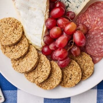Top-down view of Scottish Oat Cakes served with cheese and grapes.