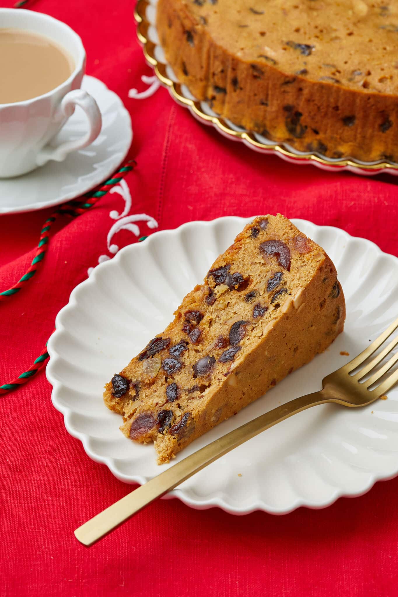 BBB_081624_7440 A slice of Irish Christmas cake served on a dessert plate with tea on the side.