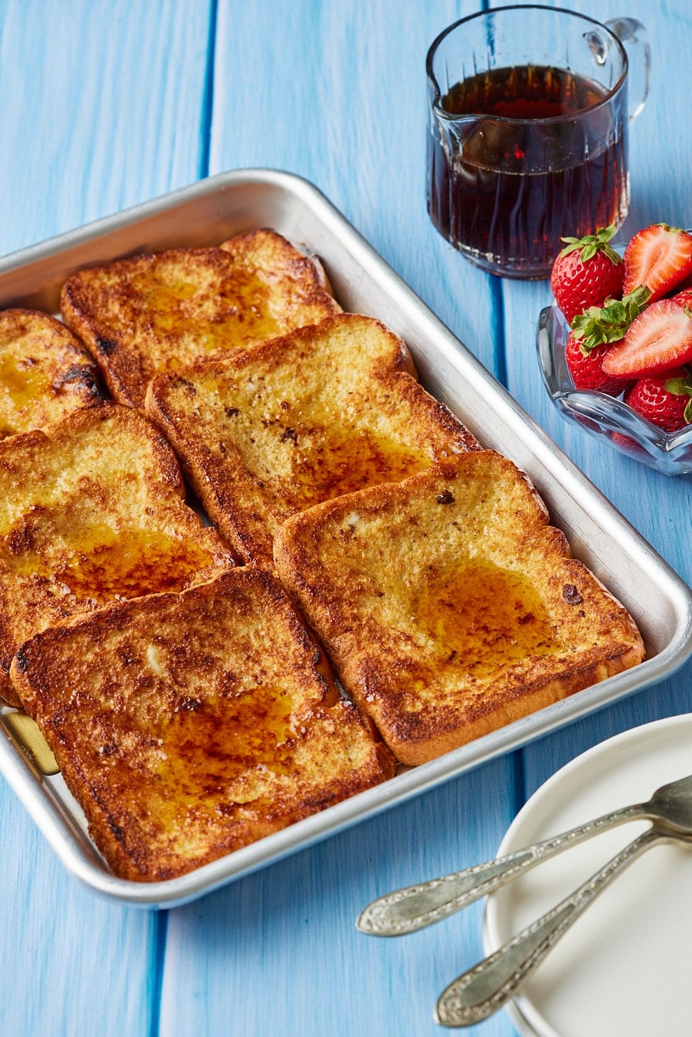 Sheet Pan French Toast7 Sheet Pan French Toast served with maple syrup and fresh strawberries.