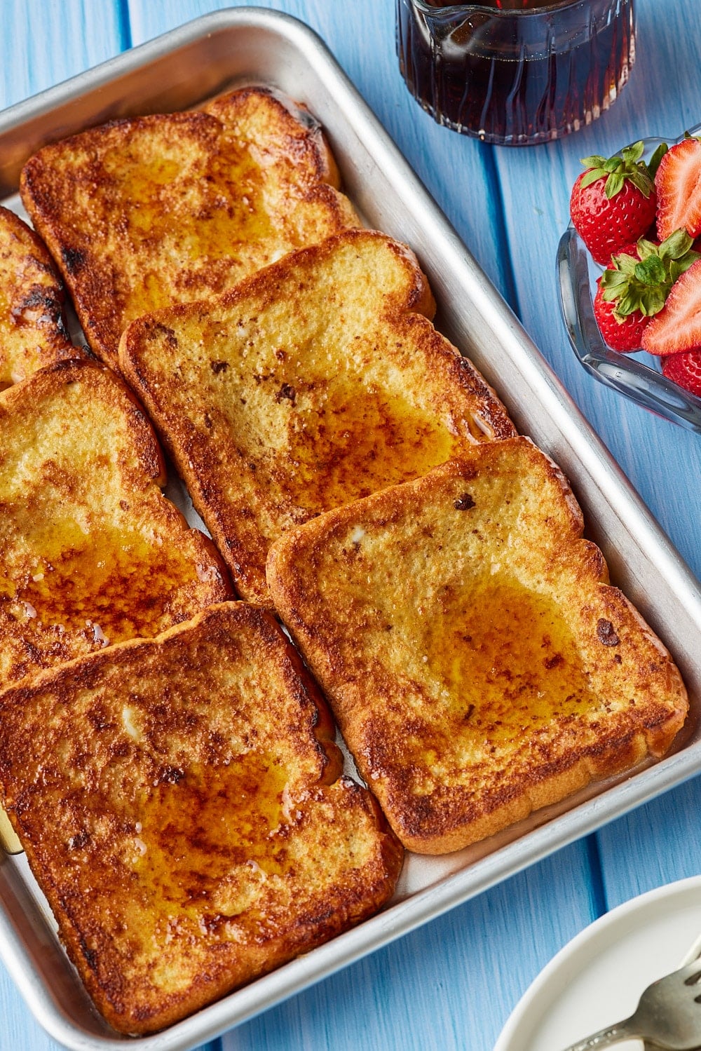 Sheet Pan French Toast8 Sheet Pan French Toast topped with maple syrup and served with fresh strawberries.