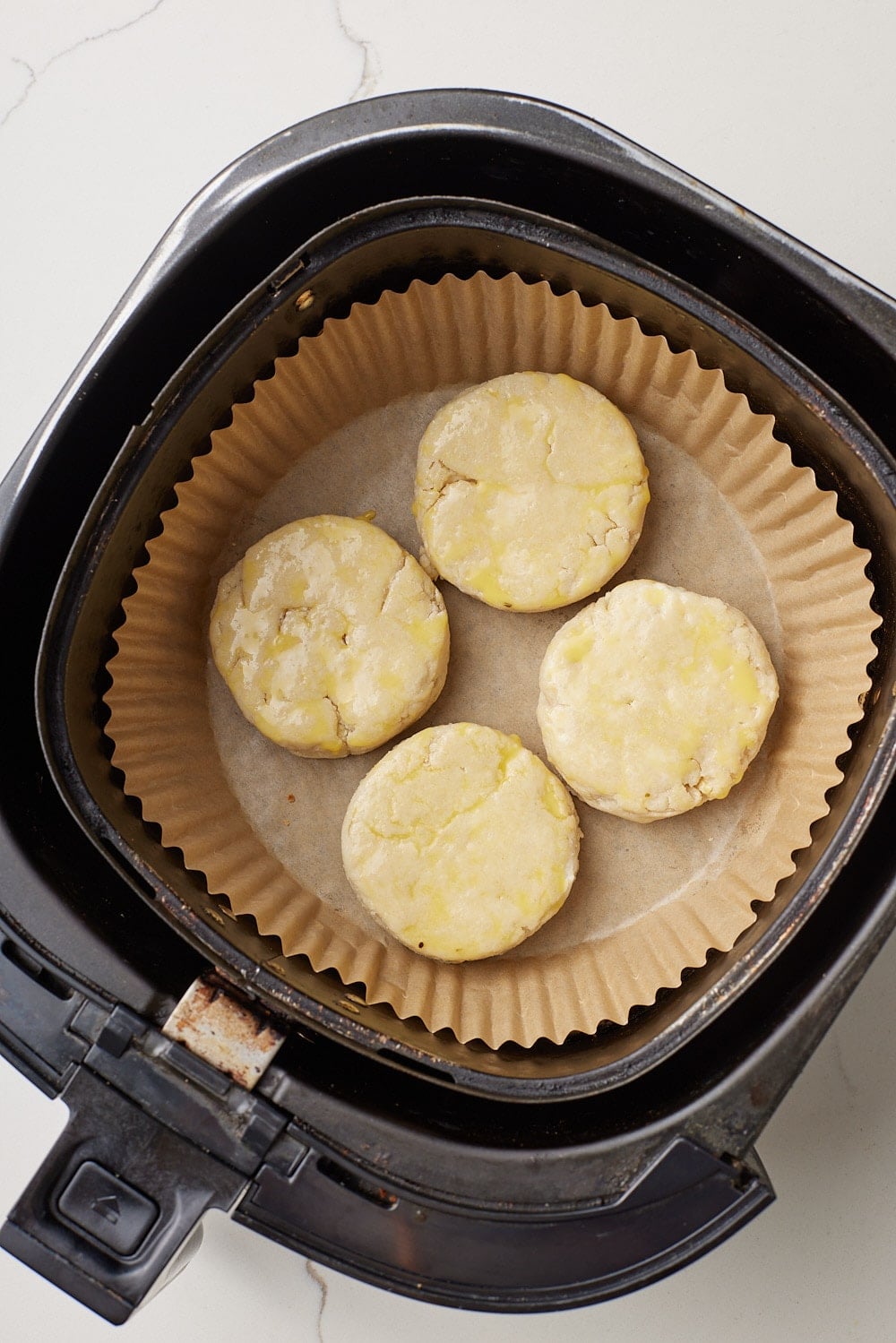 Air Fryer Scones5 Prepare to air fry. Line the air fryer basket with parchment paper and place the scones evenly spaced apart.