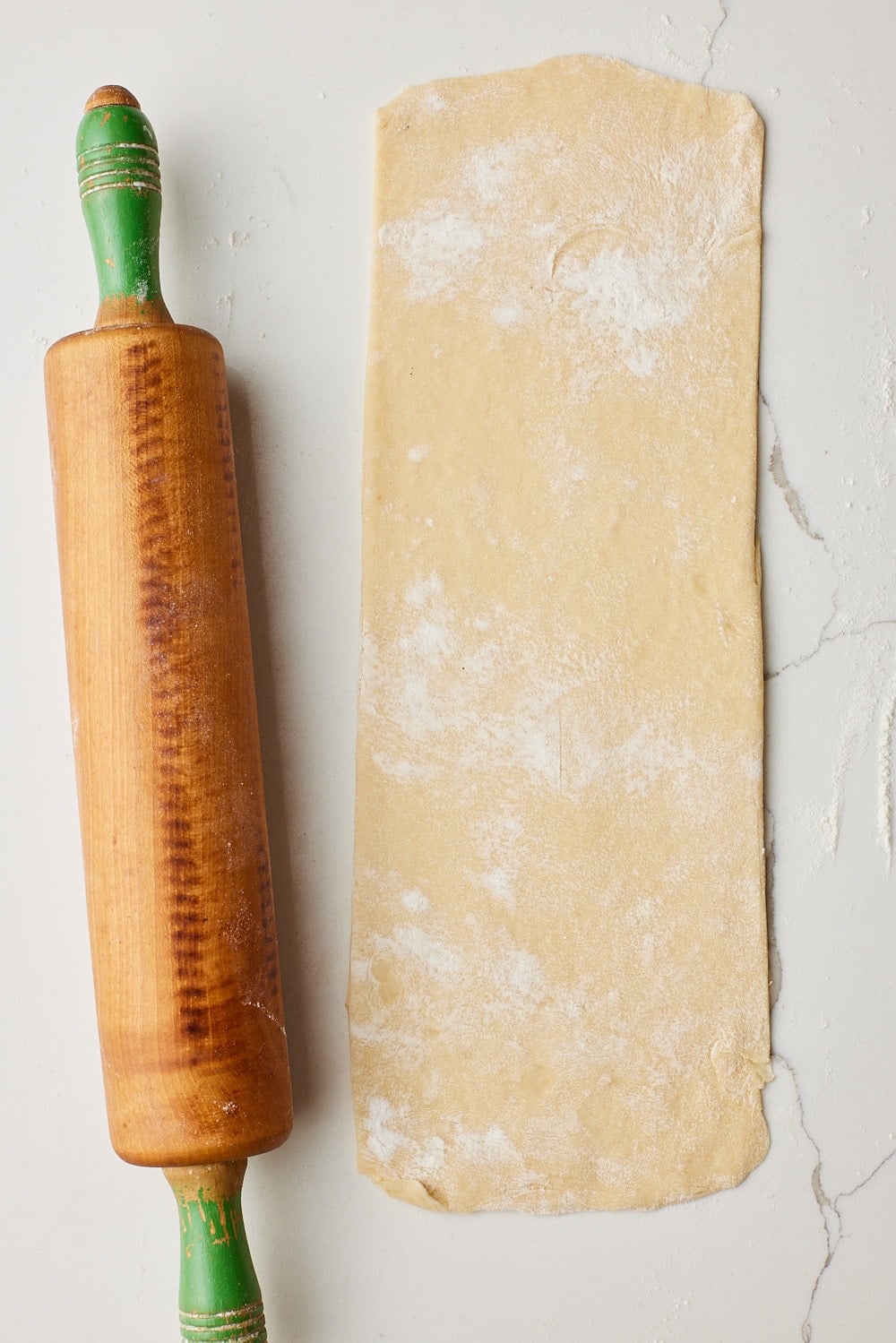 Small Batch Cinnamon Rolls7 The dough is rolled out into a rectangular with the rolling pin next to it.