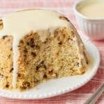 Spotted Dick steamed pudding with currants, topped with custard and served warm.